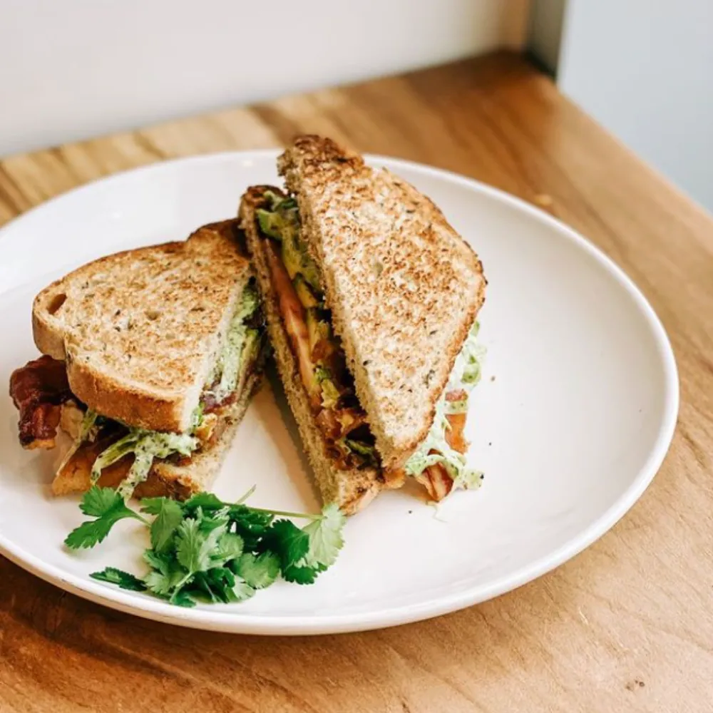 Artisan sandwich on plate on wood table.